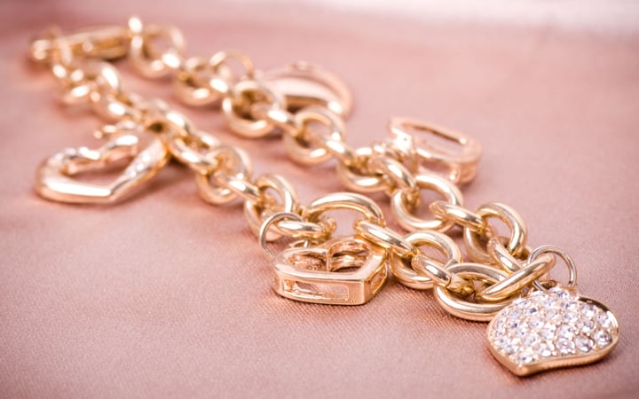 collana d'oro con cuori su sfondo rosa