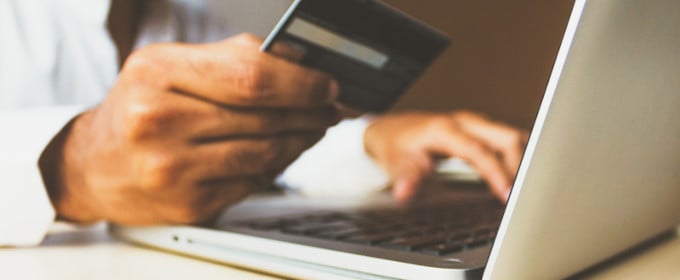Bezpieczeństwo liczy się dla kupujących najbardziej - na zdjęciu mężczyzna wprowadzający dane karty kredytowej na laptopie podczas dokonywania transakcji on-line