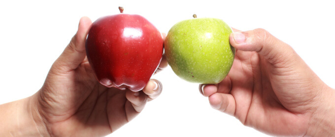 dłonie trzymające czerwone i zielone jabłko