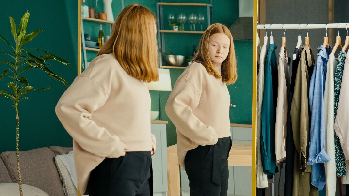 kobieta przymierzająca spodnie i przeglądająca się w lustrze
